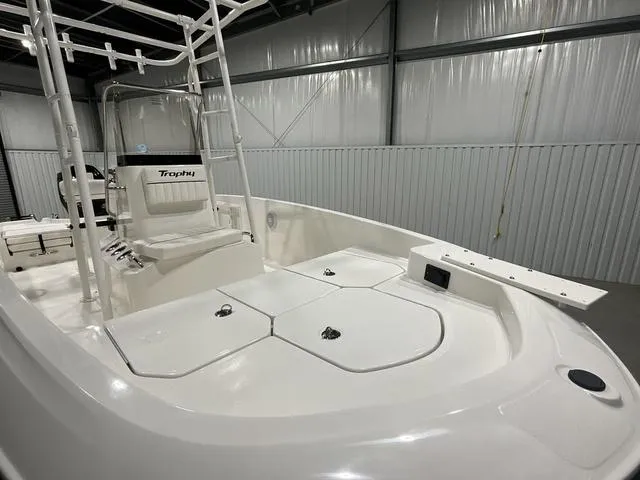 Slide: The Image of 2024 Bayliner T18BAY boat interior with white seating and storage compartments. - 9