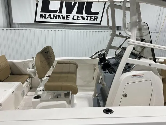 Slide: The Image of 2024 Bayliner T22CC boat interior at LMC Marine Center, featuring beige seating and control console. - 10