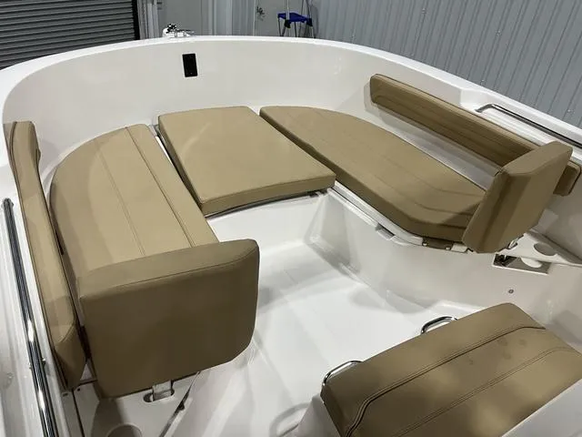 Slide: The Image of 2024 Bayliner T22CC boat interior with beige cushioned seating in a white hull. - 14