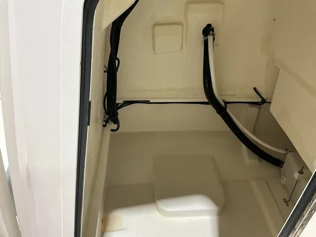 Slide: The Image of 2024 Bayliner T22CC interior compartment with wiring and tubing. - 15