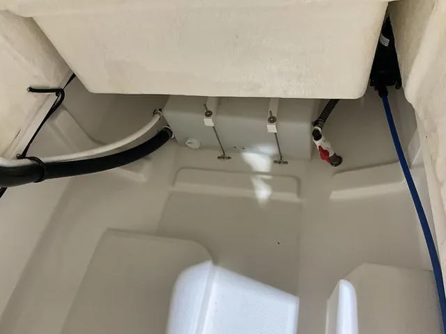 Slide: The Image of 2024 Bayliner T22CC boat interior compartment with visible hoses and fittings. - 16