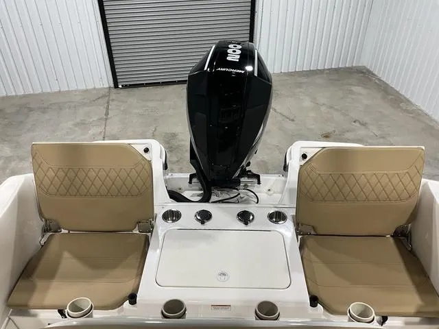 Slide: The Image of 2024 Bayliner T22CC boat interior with tan seats and Mercury 800 engine. - 17