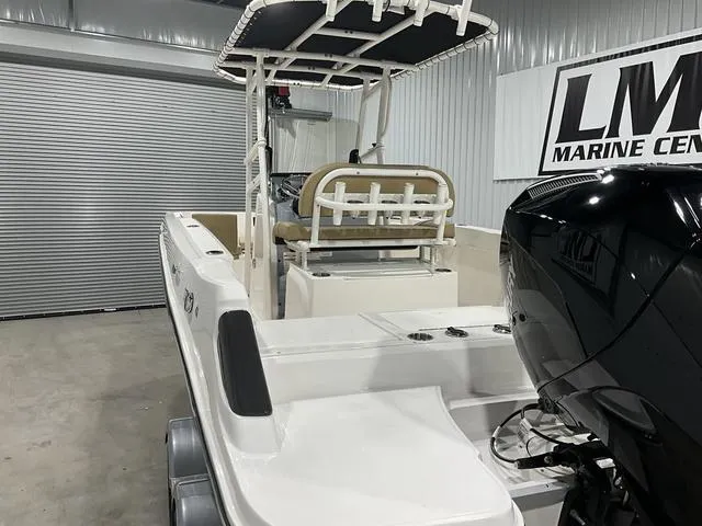 Slide: The Image of 2024 Bayliner T22CC boat in showroom, featuring sleek design and powerful outboard motor. - 18