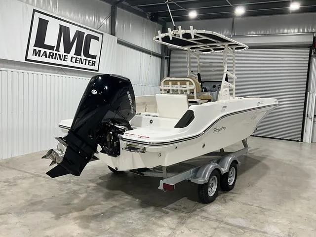 Slide: The Image of 2024 Bayliner T22CC boat in showroom, featuring outboard motor and dual-axle trailer. - 8