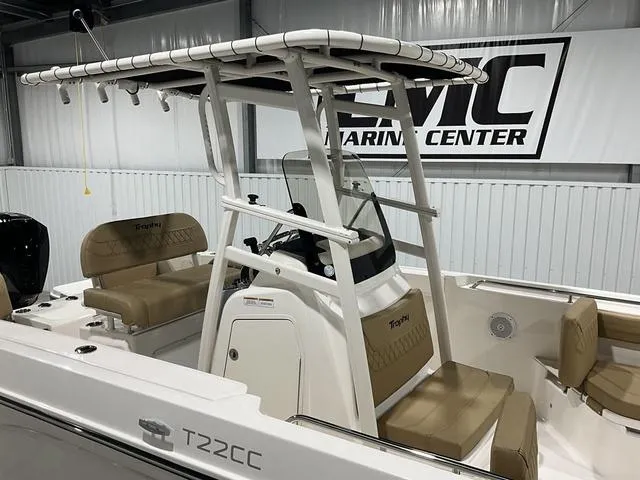 Slide: The Image of 2024 Bayliner T22CC boat interior with seating and console, displayed at a marine center. - 9