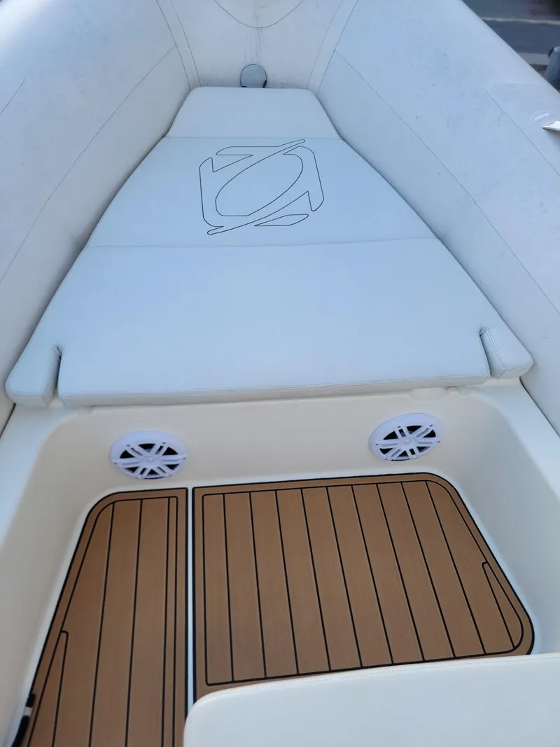 Slide: The Image of 2014 Zodiac Medline 580 boat interior with cushioned seating and teak flooring. - 12