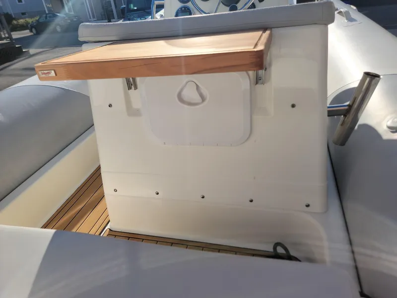 Slide: The Image of 2014 Zodiac Medline 580 boat interior with wooden table and white seating. - 14