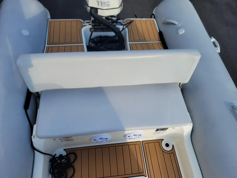 Slide: The Image of Zodiac Medline 580 2014 boat interior with cushioned seating and wooden flooring. - 15