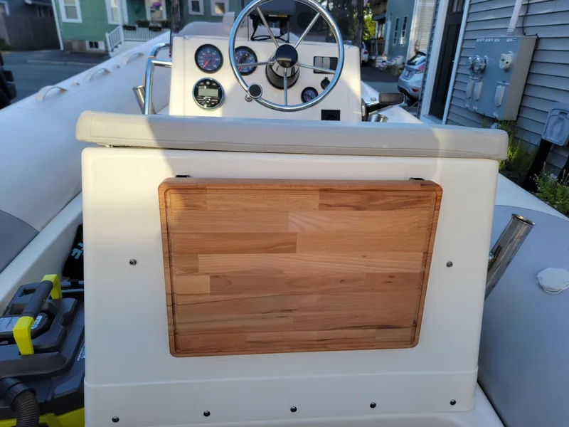 Slide: The Image of 2014 Zodiac Medline 580 boat dashboard with wooden panel and steering wheel. - 30