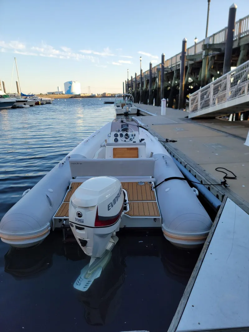 Slide: The Image of 2014 Zodiac Medline 580 boat docked at a marina with Evinrude outboard motor. - 5