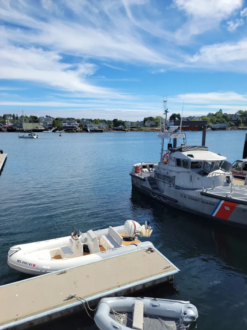 Slide: The Image of 2014 Zodiac Medline 580 docked near a coast guard boat on a sunny day. - 8