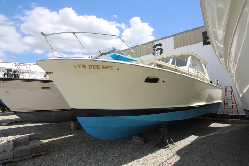 Slide: The Image of 1965 Chris-Craft Commander boat Lyn Dee Bee on dry dock under a clear blue sky. - 1