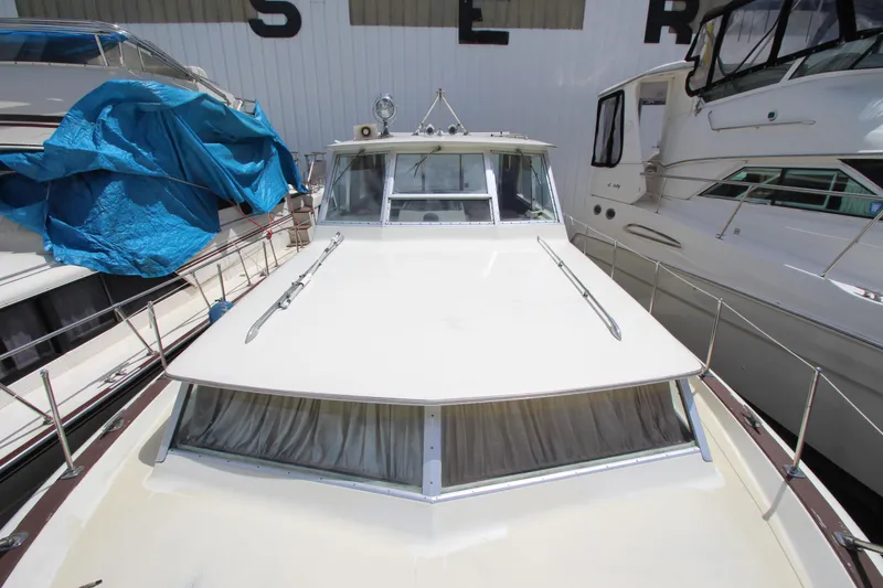 Slide: The Image of 1965 Chris-Craft Commander boat docked between other vessels in a marina. - 12