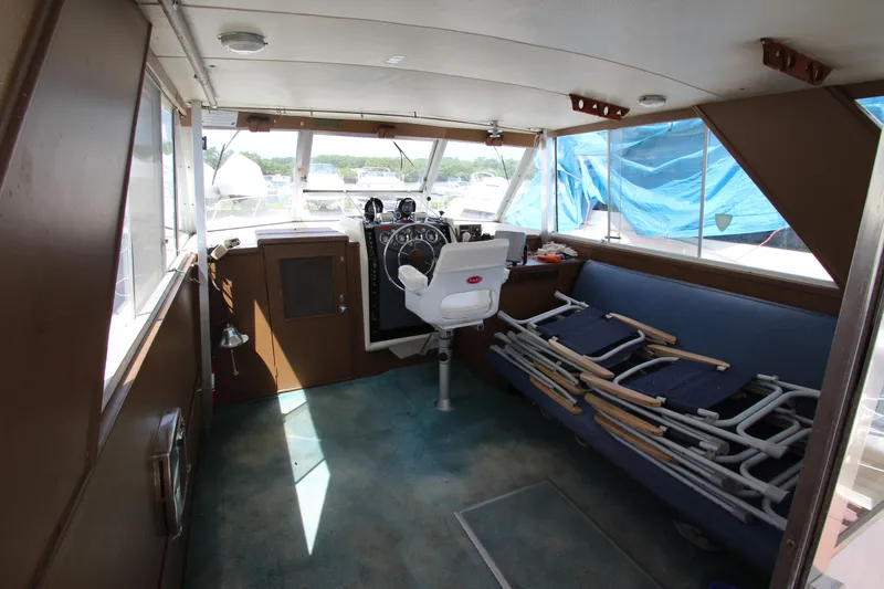 Slide: The Image of 1965 Chris-Craft Commander boat interior with helm, seating, and folded deck chairs. - 16