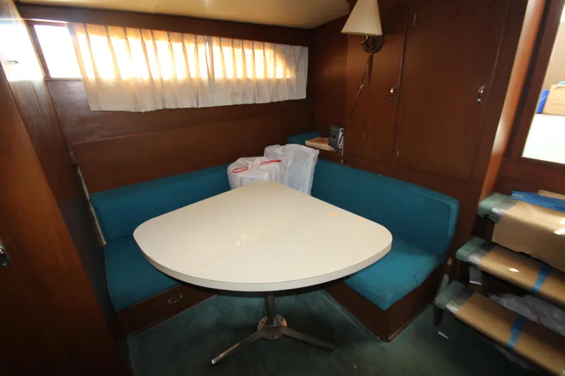 Slide: The Image of 1965 Chris-Craft Commander interior with dining area, teal seating, and wooden cabinetry. - 23