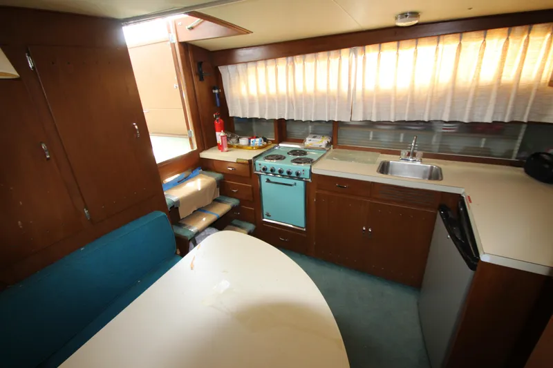 Slide: The Image of 1965 Chris-Craft Commander kitchen interior with stove, sink, and dining area. - 25