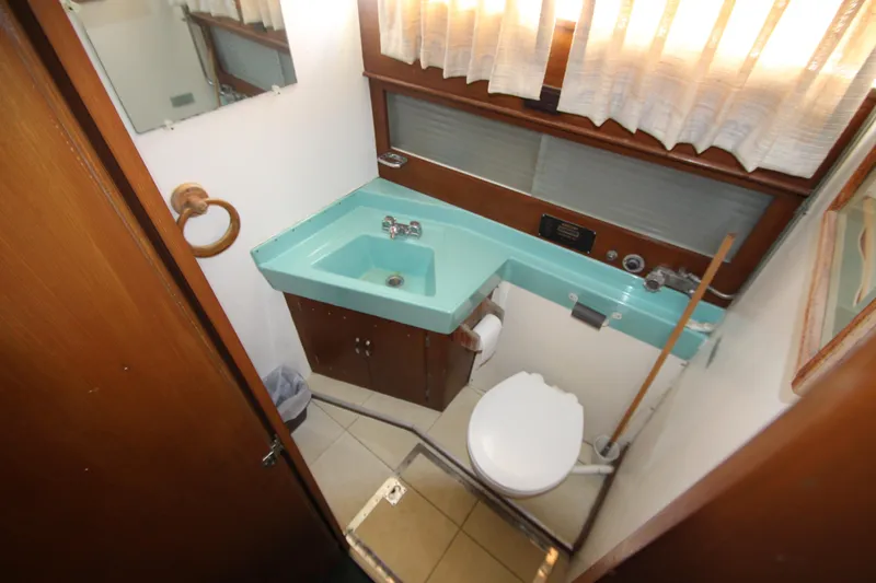 Slide: The Image of 1965 Chris-Craft Commander bathroom with turquoise sink, toilet, and wooden cabinetry. - 28