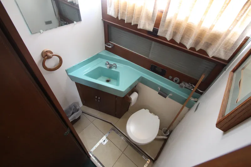 Slide: The Image of 1965 Chris-Craft Commander bathroom with turquoise sink, toilet, and wooden accents. - 31