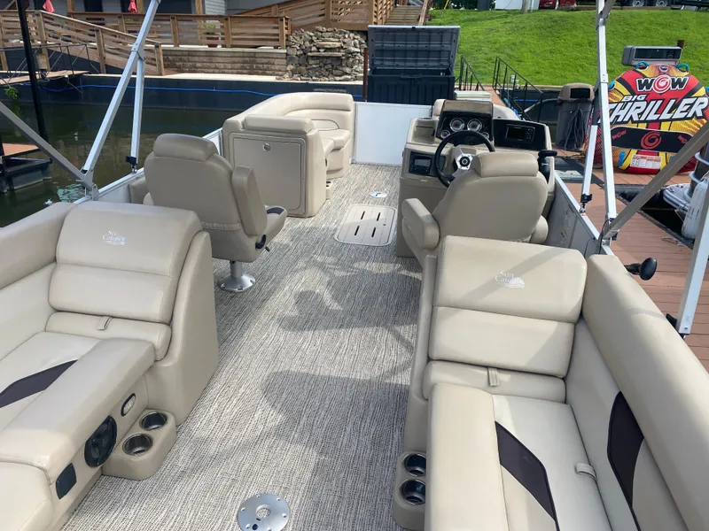 Slide: The Image of 2022 SunCatcher Select 322RC pontoon boat interior with beige seating and modern dashboard. - 4