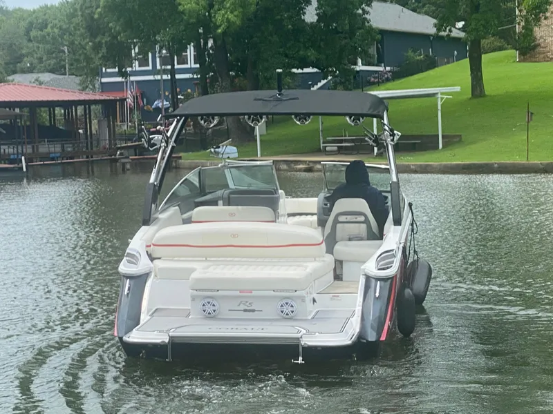 Slide: The Image of 2016 Cobalt R5 WSS boat cruising on a lake near a dock and green lawn. - 9