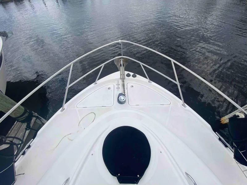 Slide: The Image of Bow view of a 2004 Meridian 381 Sedan yacht docked on calm water. - 11