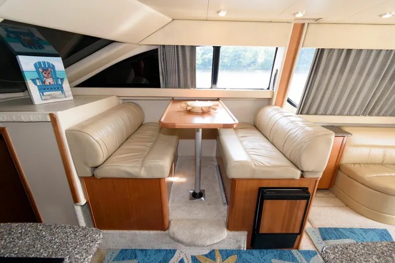 Slide: The Image of 2004 Meridian 381 Sedan interior dining area with beige leather seating and wooden table. - 19