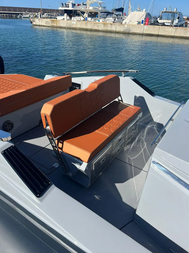 Slide: The Image of Modern DNA 46 boat (2025) with orange seating at a marina. - 15