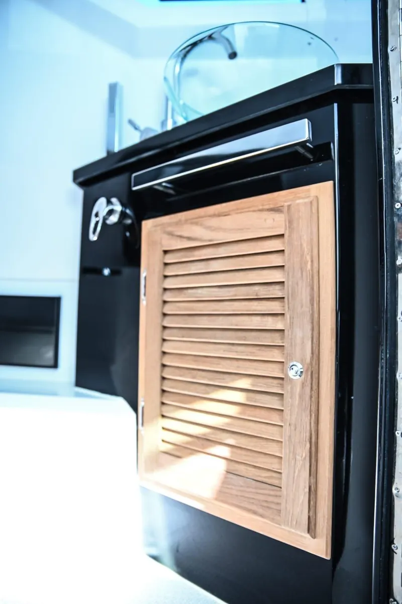Slide: The Image of Modern DNA 46 yacht interior with sleek black cabinetry and wooden louvered door, 2025 model. - 21