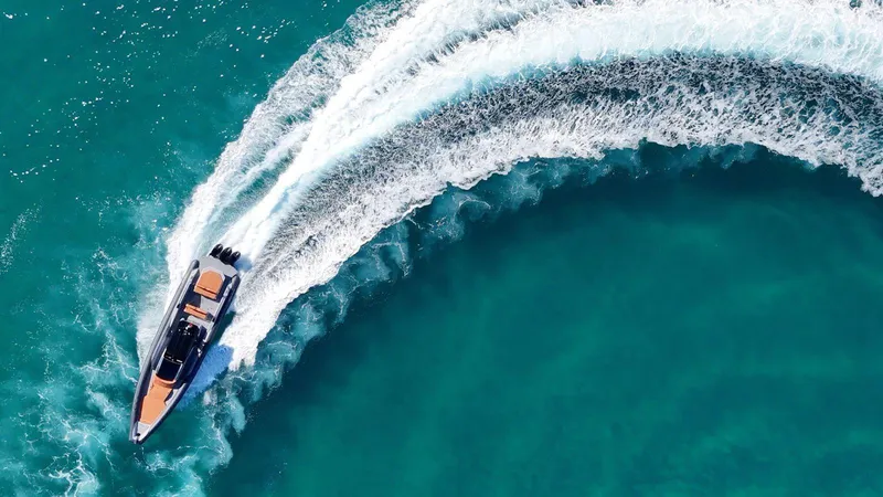 Slide: The Image of Aerial view of DNA 46 speedboat making a sharp turn in turquoise water. - 7