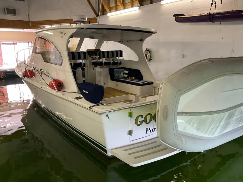Slide: The Image of 2000 Mainship Pilot boat docked indoors, featuring open cockpit and seating. - 10