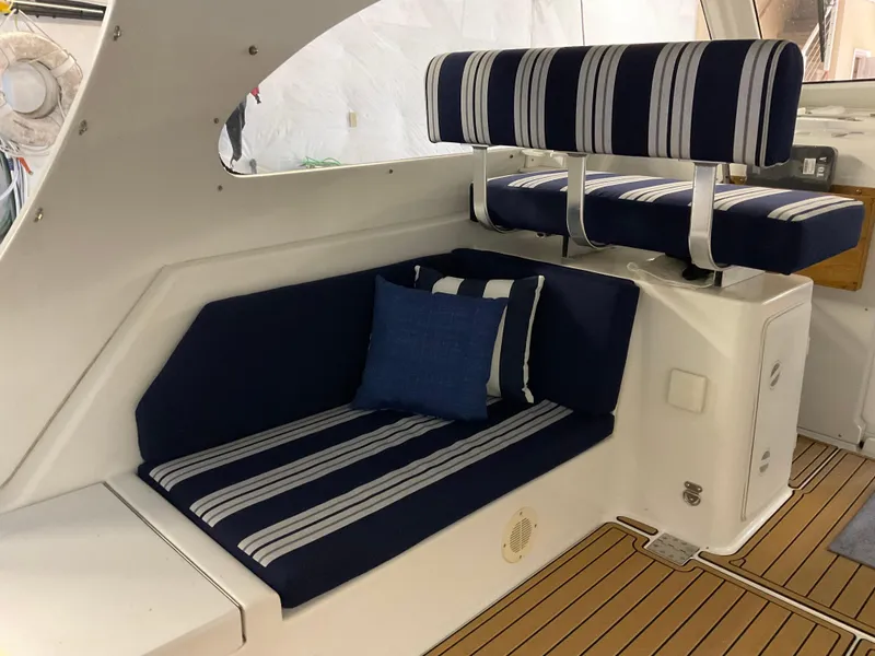 Slide: The Image of 2000 Mainship Pilot boat interior with striped navy seating and wooden flooring. - 11
