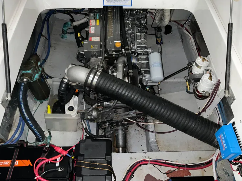 Slide: The Image of Engine compartment of a 2000 Mainship Pilot boat, showcasing mechanical components and wiring. - 13