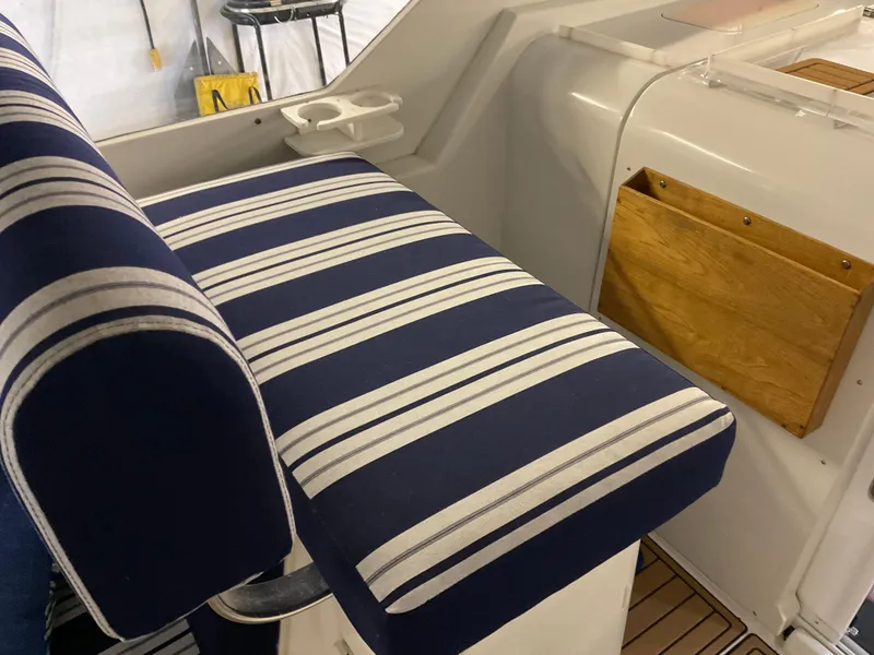 Slide: The Image of 2000 Mainship Pilot boat interior with striped seating and wooden storage. - 16