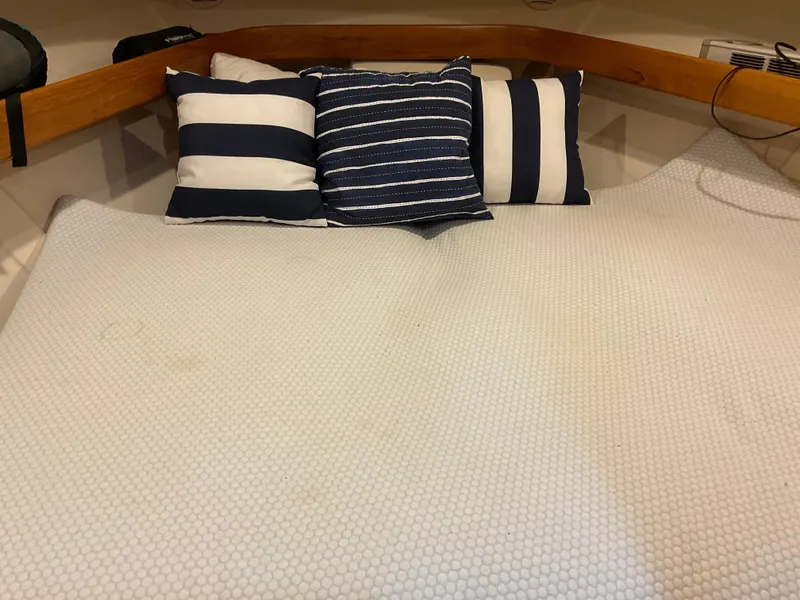 Slide: The Image of Cozy cabin bed with striped pillows on a 2000 Mainship Pilot boat. - 20