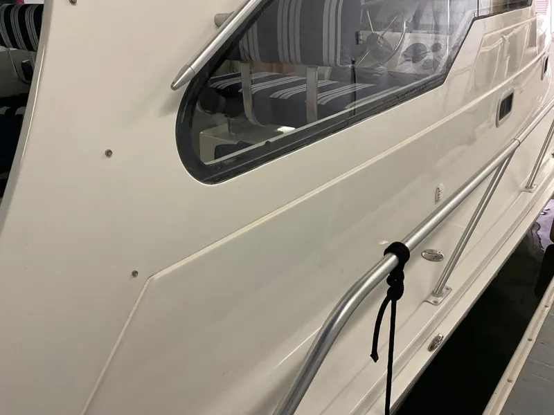 Slide: The Image of 2000 Mainship Pilot boat side view with window and railing detail. - 24