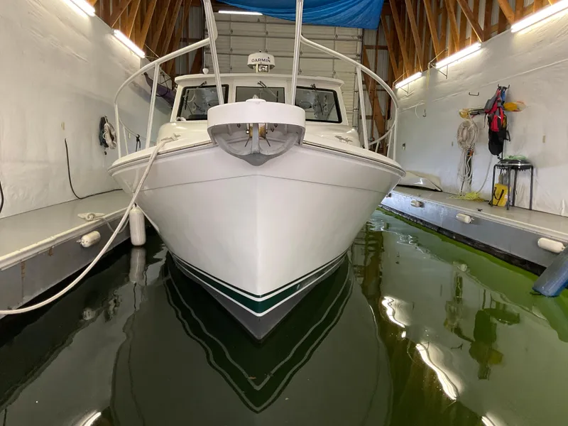 Slide: The Image of 2000 Mainship Pilot boat docked in indoor marina with green water. - 27