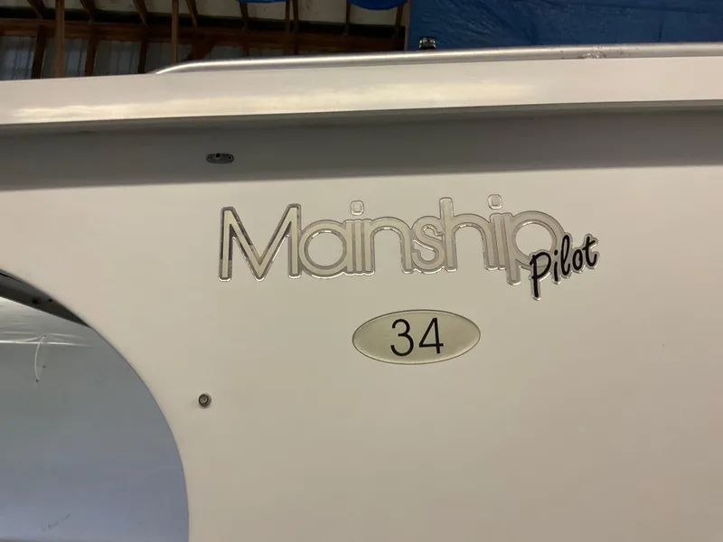 Slide: The Image of 2000 Mainship Pilot 34 boat logo on white hull. - 3