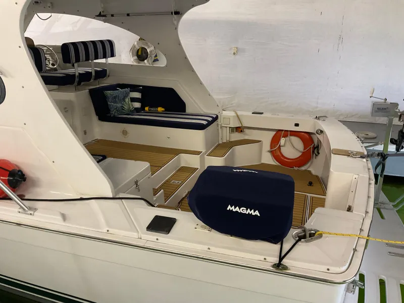 Slide: The Image of 2000 Mainship Pilot boat interior with seating, life preserver, and Magma grill cover. - 9
