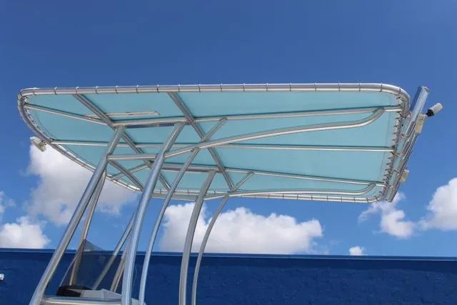Slide: The Image of T-top canopy of 2021 Blue Wave 2000 Pure Bay boat against blue sky. - 24