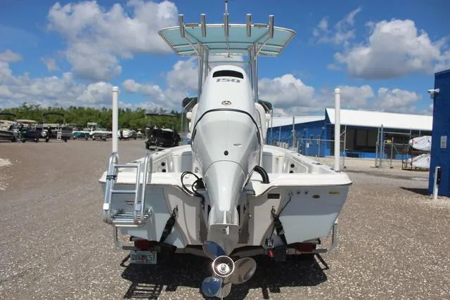 Slide: The Image of 2021 Blue Wave 2000 Pure Bay boat, rear view, parked outdoors under a blue sky. - 5