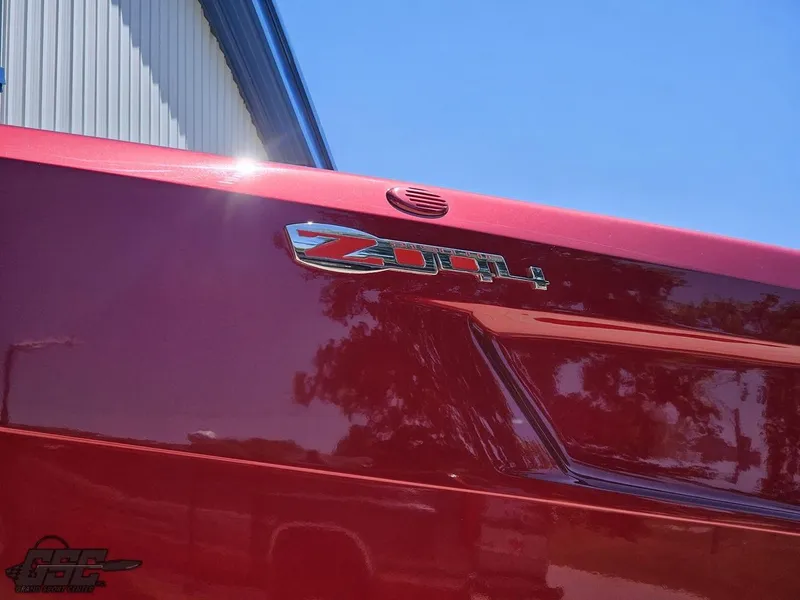 Slide: The Image of Red 2010 MTI 44 Corvette boat on trailer at Grand Sport Center, under blue sky. - 12