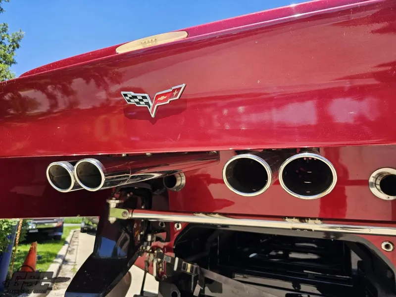 Slide: The Image of 2010 MTI 44 Corvette boat with reflective black surface, parked outdoors under blue sky. - 16