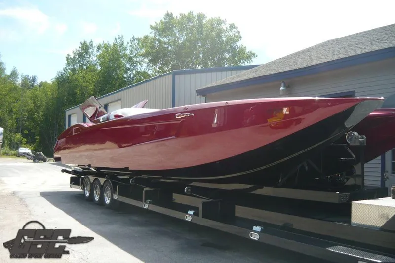Slide: The Image of Red 2010 MTI 44 Corvette powerboat on trailer at marina, surrounded by other boats. - 18