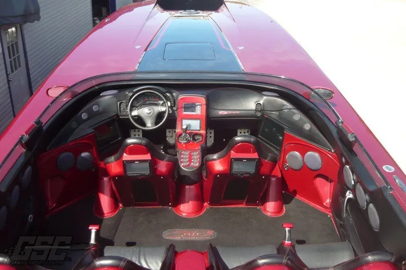 Slide: The Image of 2010 MTI 44 Corvette powerboat on trailer, sleek red and black design, parked outdoors. - 23