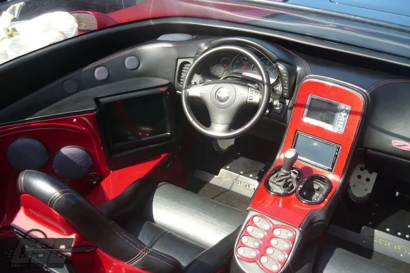 Slide: The Image of 2010 MTI 44 Corvette boat on trailer, featuring sleek red and black hull design. - 24