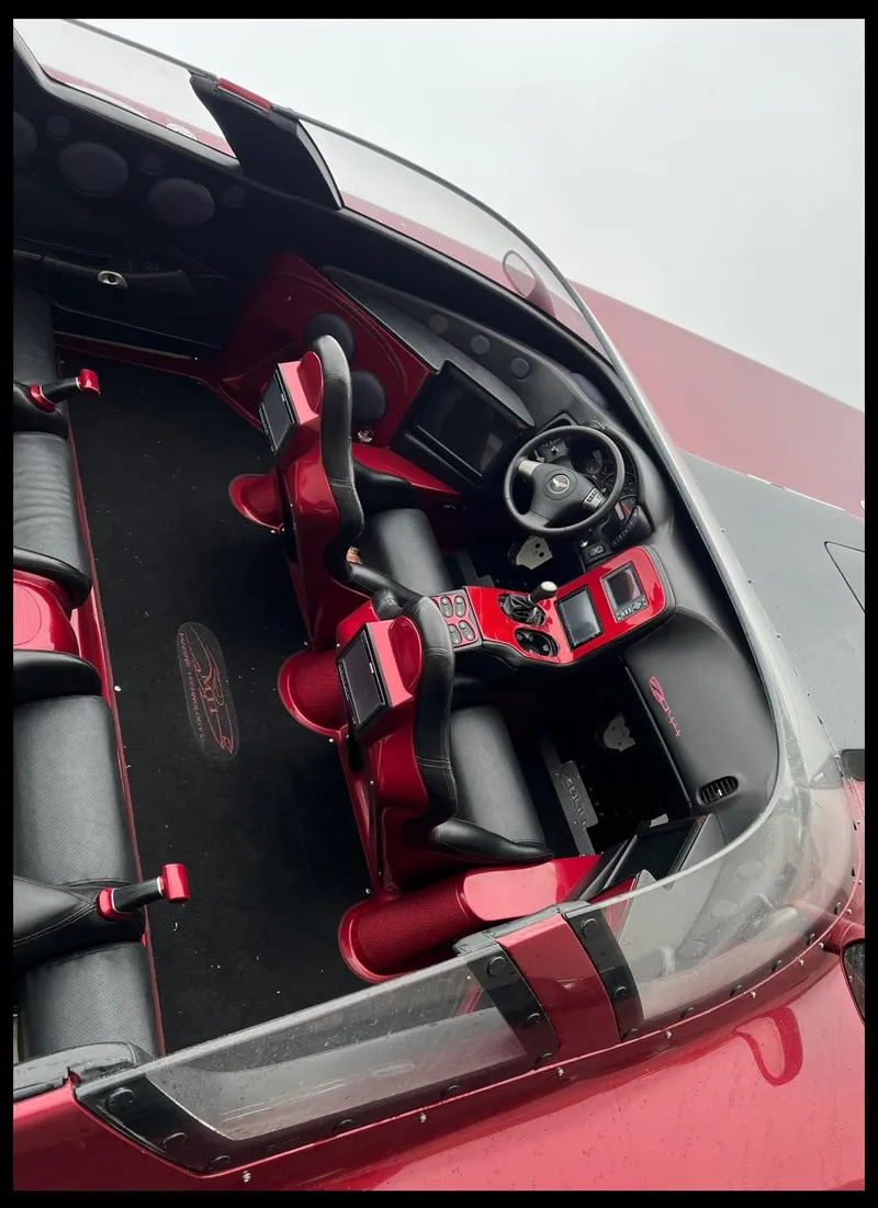 Slide: The Image of Interior of a 2010 MTI 44 Corvette boat with sleek red and black design. - 40