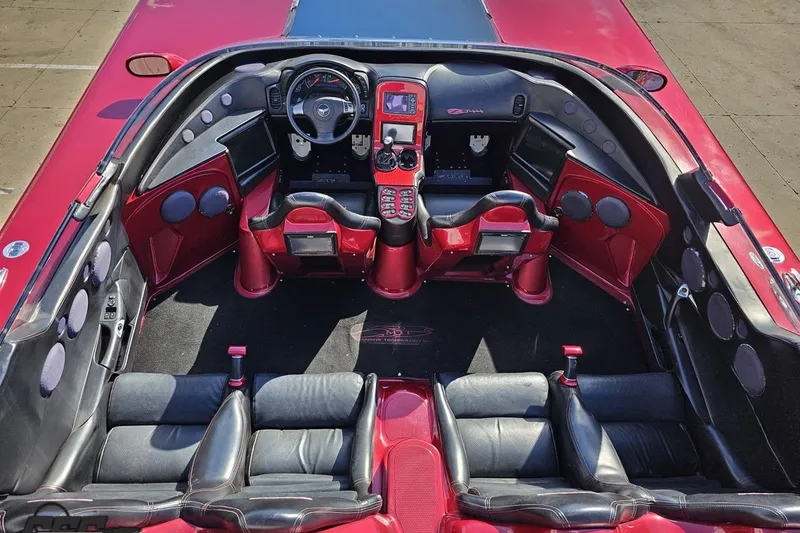 Slide: The Image of Interior of a 2010 MTI 44 Corvette, featuring red and black leather seats and advanced dashboard. - 42