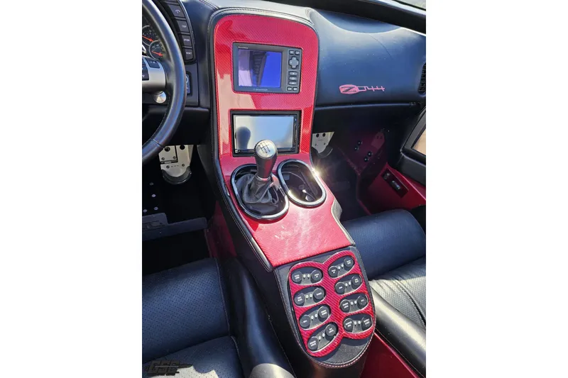Slide: The Image of 2010 MTI 44 Corvette interior with red carbon fiber console and manual gear shift. - 50