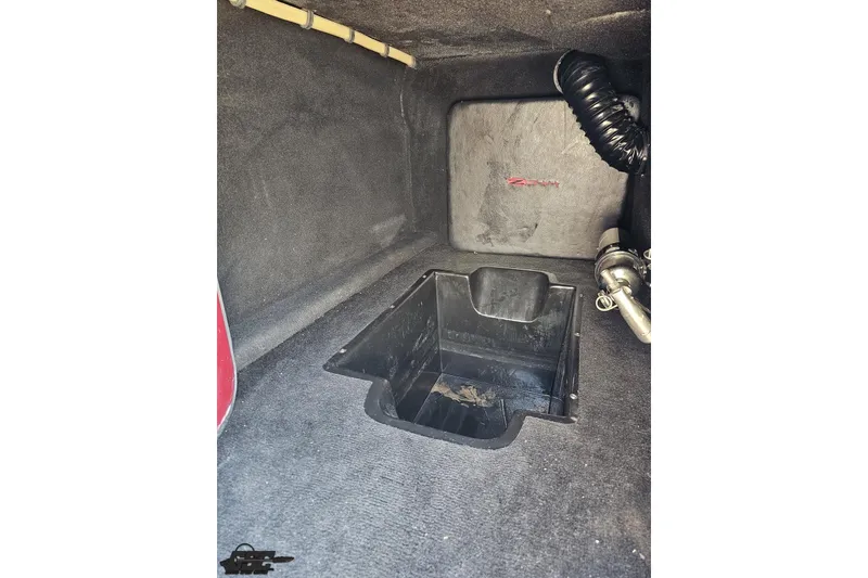 Slide: The Image of Interior view of a 2010 MTI 44 Corvette storage compartment with black lining. - 57