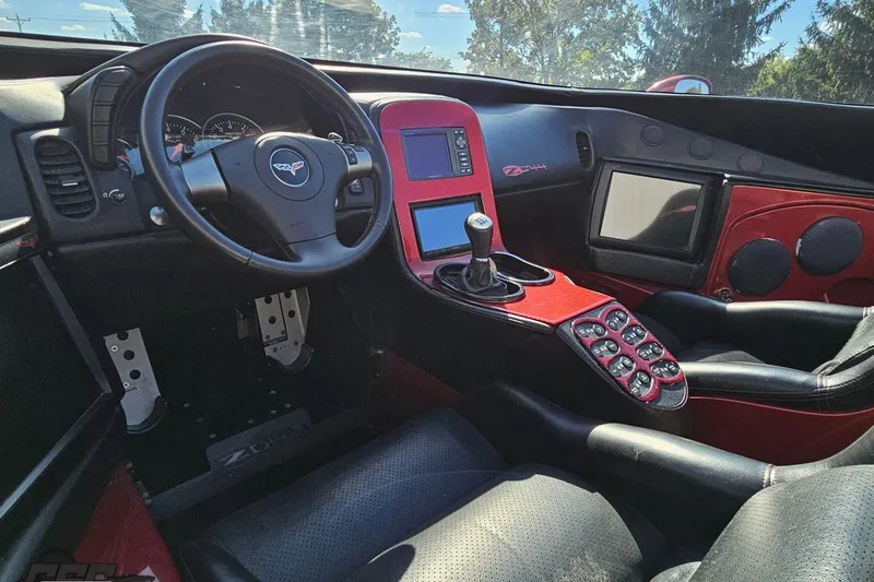 Slide: The Image of 2010 MTI 44 Corvette interior with custom red and black design, featuring advanced controls. - 58